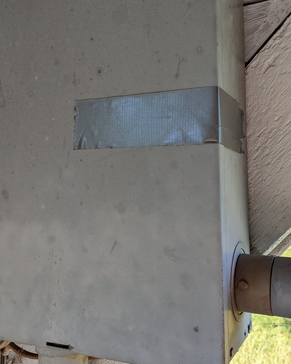The exterior electrical enclosure taped shut across its cover seam.